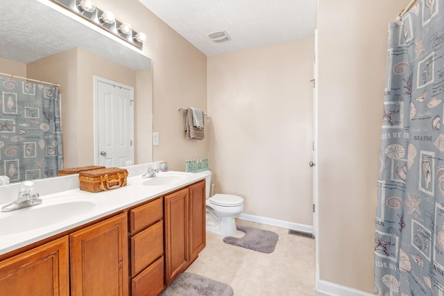 bathroom featuring a textured ceiling, toilet, vanity, and walk in shower