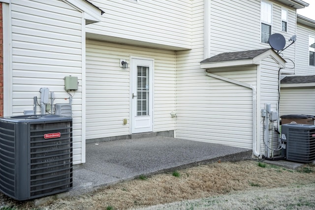 view of exterior entry with central air condition unit and a patio area