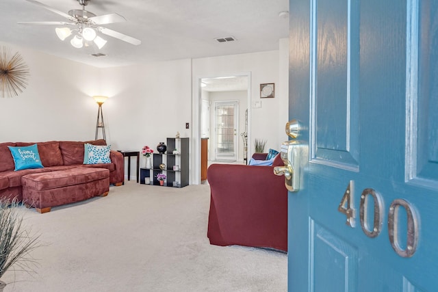 carpeted living room featuring ceiling fan