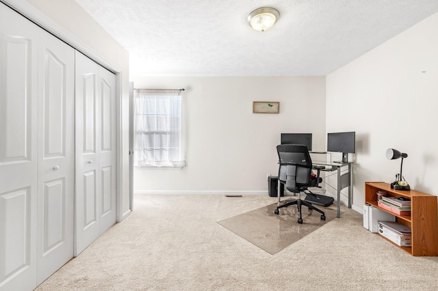 carpeted home office with a textured ceiling