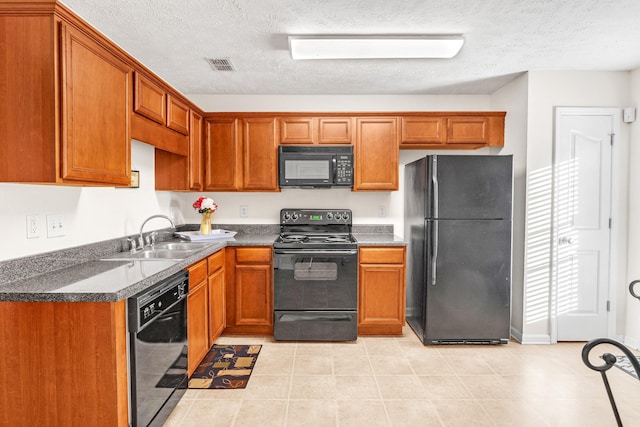 kitchen featuring sink, a textured ceiling, light tile patterned floors, and black appliances