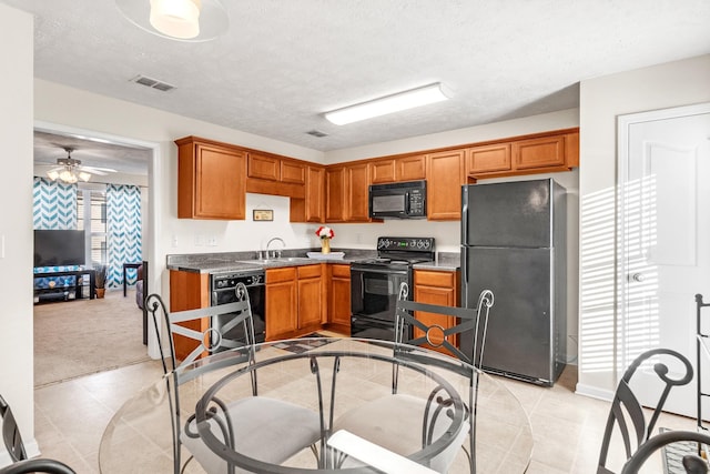 kitchen with ceiling fan, light colored carpet, black appliances, sink, and a textured ceiling