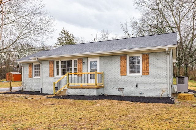 ranch-style house featuring a front yard, a deck, and central air condition unit