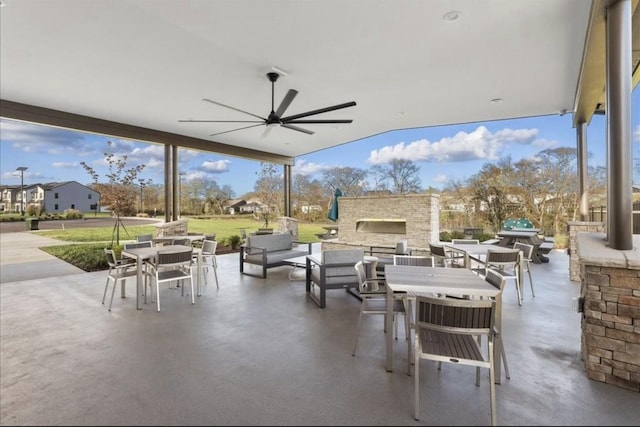 view of patio / terrace featuring ceiling fan and an outdoor stone fireplace