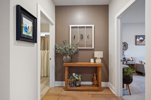 hallway with light wood-style flooring and baseboards