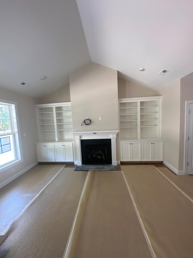 unfurnished living room with vaulted ceiling