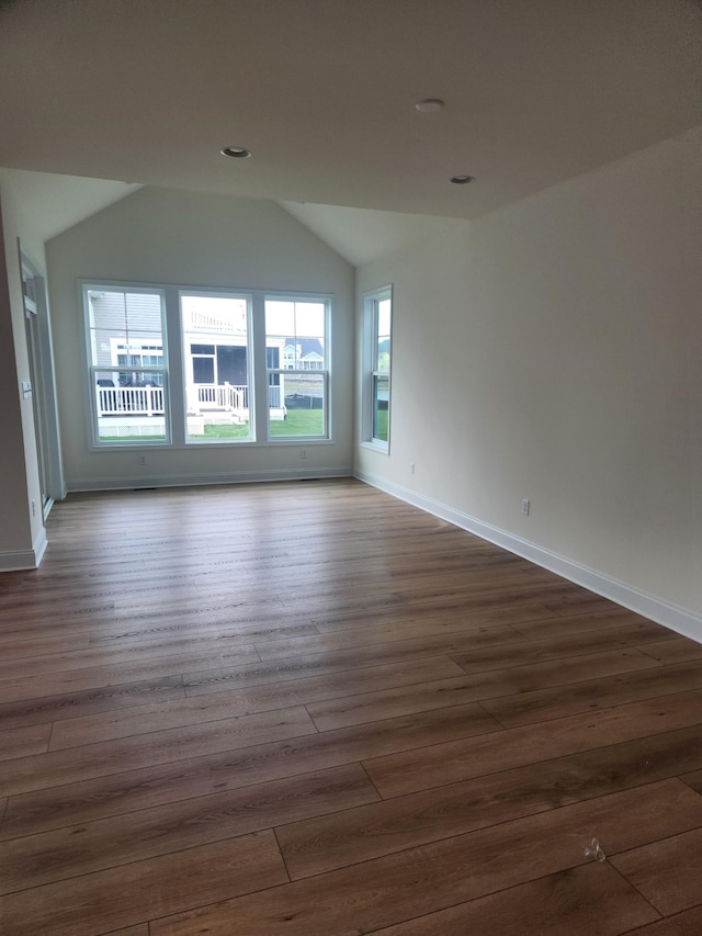 unfurnished room featuring dark hardwood / wood-style flooring and lofted ceiling