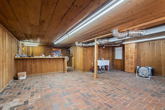 basement with wood ceiling and wood walls