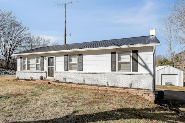 ranch-style house with a front lawn, a garage, and an outbuilding