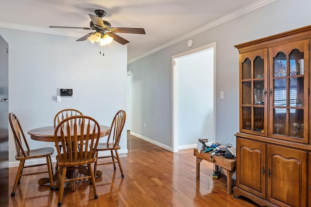 dining room with ceiling fan, crown molding, and hardwood / wood-style flooring