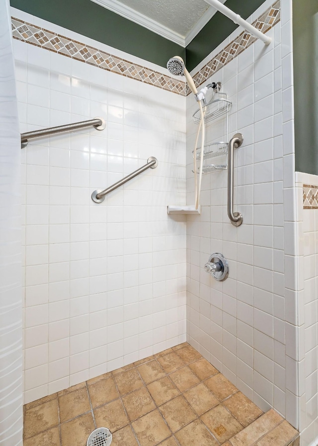 bathroom featuring a textured ceiling, a tile shower, and ornamental molding