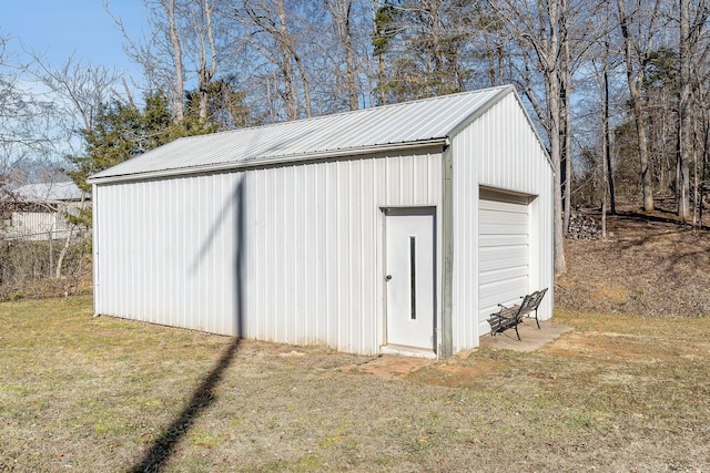 view of outdoor structure with a lawn and a garage