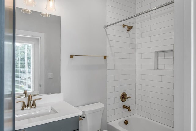 full bathroom featuring tiled shower / bath combo, vanity, and toilet