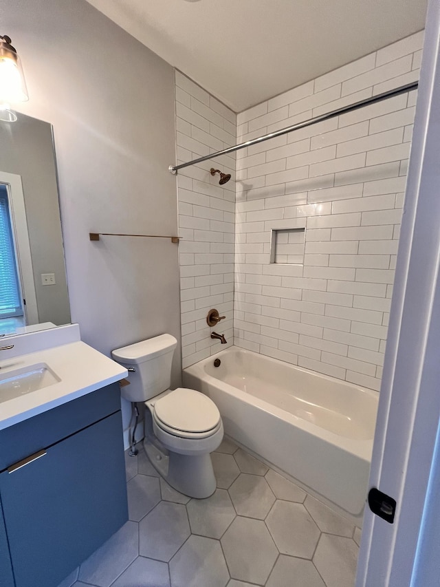 full bathroom with toilet, tile patterned floors, tiled shower / bath, and vanity