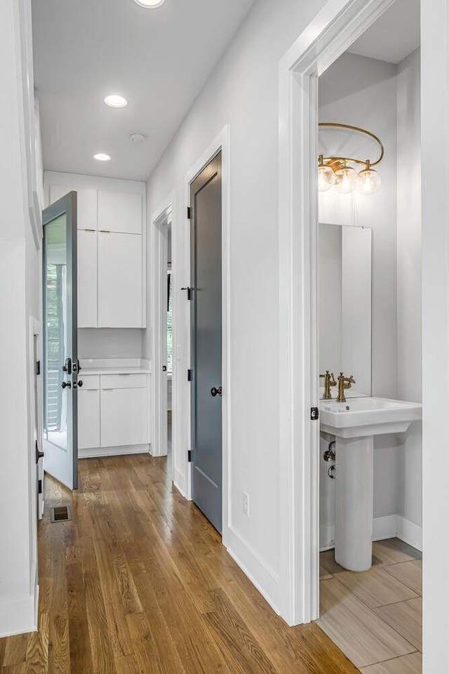 hall with sink and hardwood / wood-style flooring