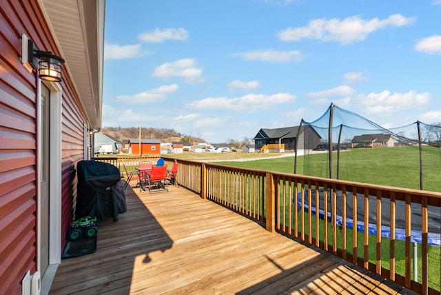 wooden terrace with a yard and grilling area