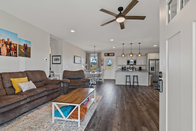 living room featuring ceiling fan and dark hardwood / wood-style floors