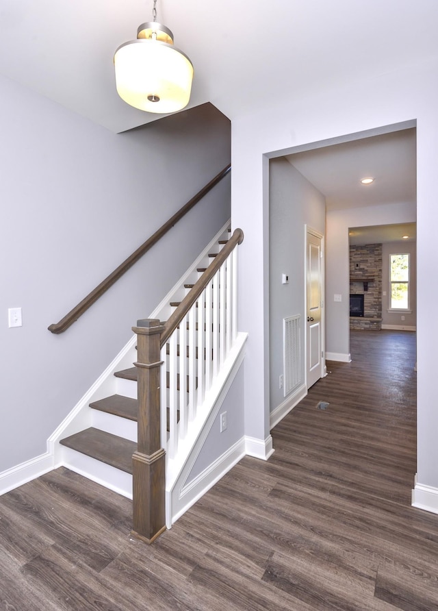 stairs featuring a fireplace and hardwood / wood-style flooring