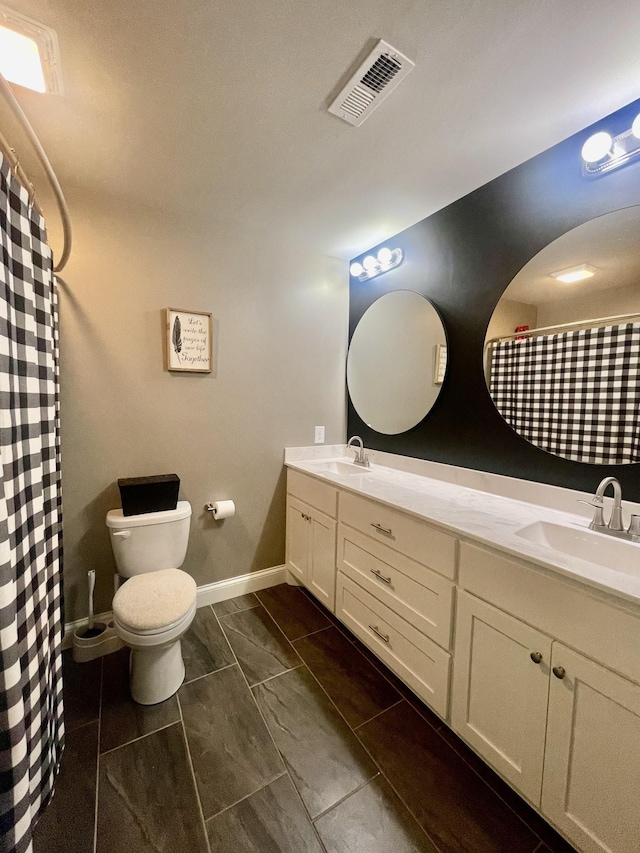 bathroom featuring toilet, vanity, and curtained shower