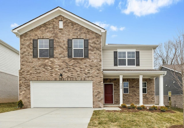 view of front of home with a garage, a front lawn, and covered porch