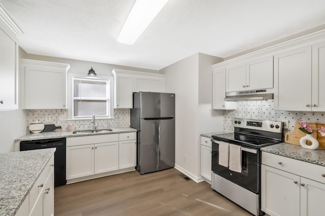 kitchen featuring appliances with stainless steel finishes, sink, white cabinets, hardwood / wood-style flooring, and light stone counters