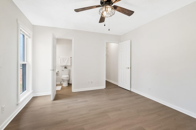 unfurnished bedroom with wood-type flooring, ensuite bathroom, and ceiling fan