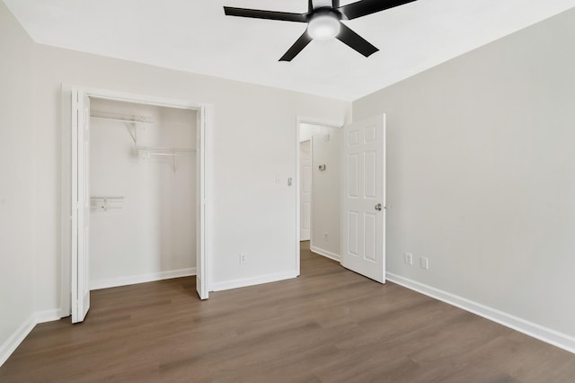 unfurnished bedroom with ceiling fan, dark hardwood / wood-style flooring, and a closet