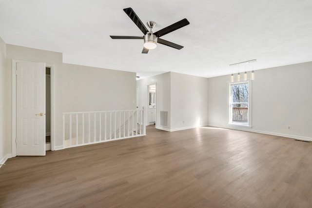 unfurnished room with ceiling fan, dark hardwood / wood-style floors, and track lighting