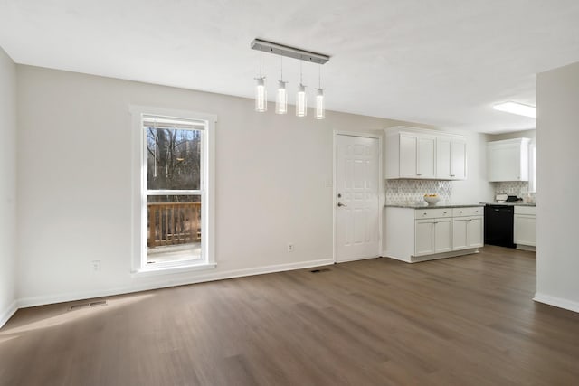 kitchen with black dishwasher, rail lighting, white cabinets, pendant lighting, and backsplash