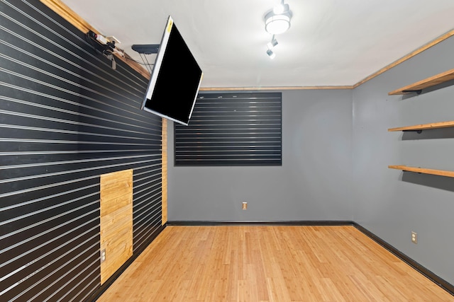 spare room with crown molding and wood-type flooring