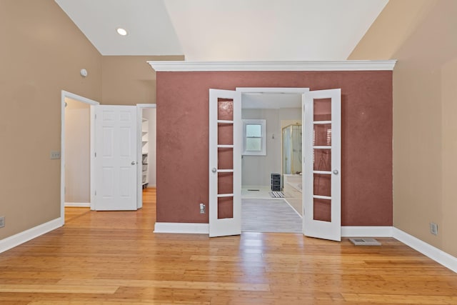 spare room with light hardwood / wood-style floors, high vaulted ceiling, and french doors