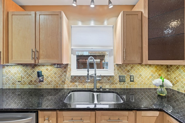 kitchen with sink, dark stone countertops, dishwasher, and backsplash