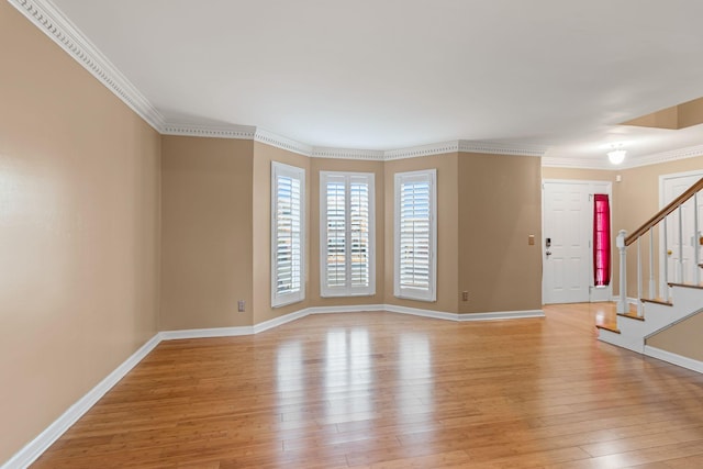 empty room with ornamental molding and light wood-type flooring