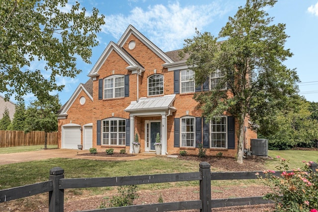 view of front of property featuring a front yard, central air condition unit, and a garage