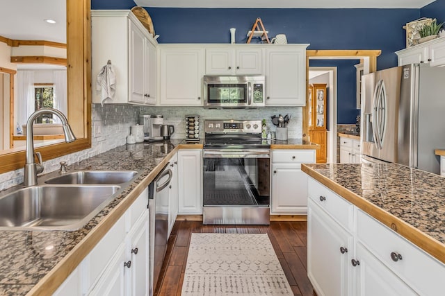 kitchen featuring backsplash, sink, white cabinetry, appliances with stainless steel finishes, and dark hardwood / wood-style flooring