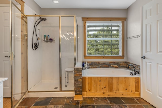 bathroom featuring shower with separate bathtub