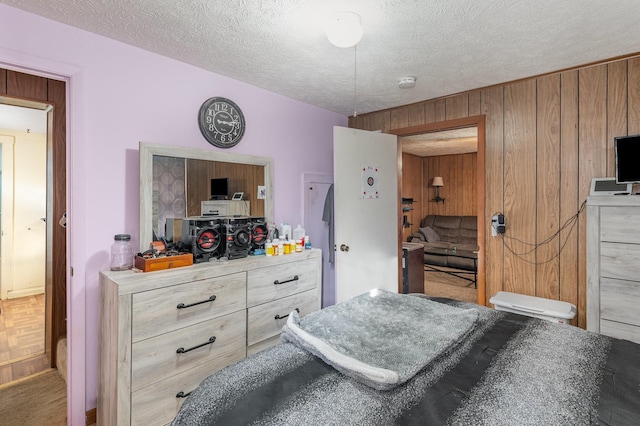 bedroom with wooden walls and a textured ceiling