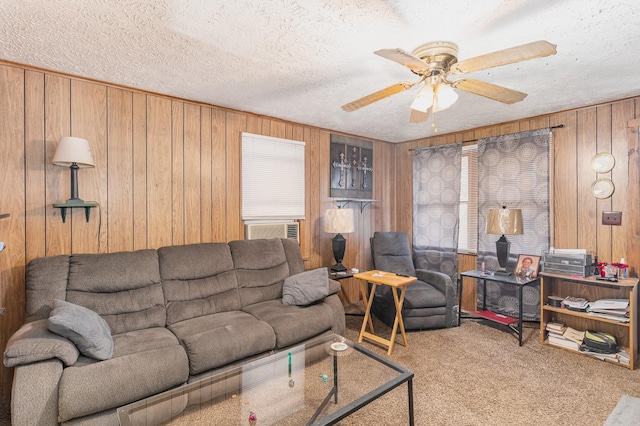 carpeted living room with ceiling fan, wooden walls, and a textured ceiling