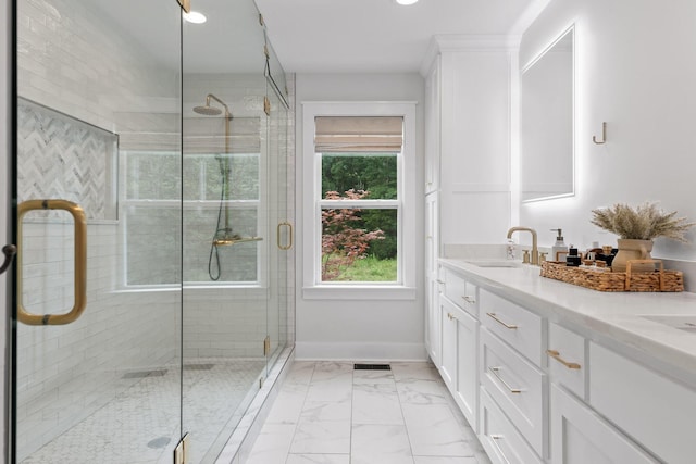 full bathroom featuring a shower stall, baseboards, double vanity, marble finish floor, and a sink