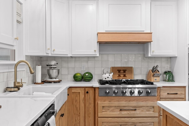 kitchen featuring extractor fan, light countertops, appliances with stainless steel finishes, white cabinets, and a sink