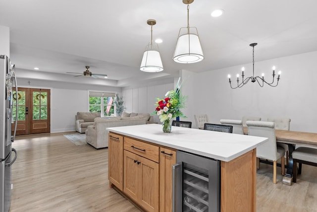 kitchen featuring recessed lighting, light wood-style flooring, pendant lighting, and beverage cooler