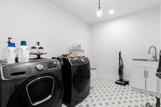 laundry room featuring light floors, baseboards, cabinet space, separate washer and dryer, and a sink