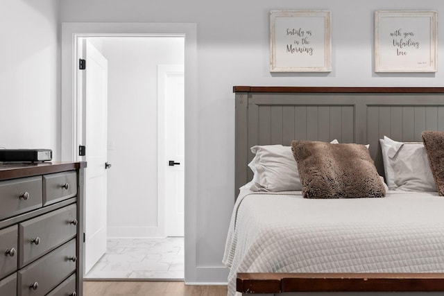 bedroom featuring baseboards and marble finish floor