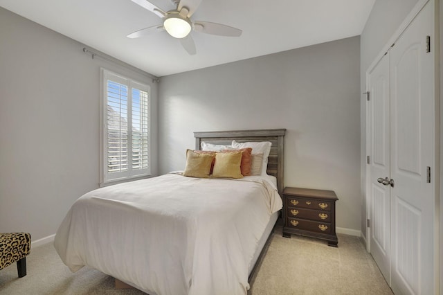 bedroom featuring ceiling fan, a closet, and light carpet