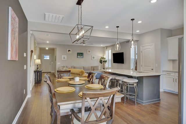 dining room with hardwood / wood-style floors and a notable chandelier