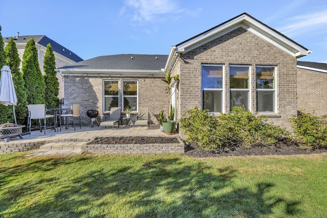 rear view of property with a yard and a patio