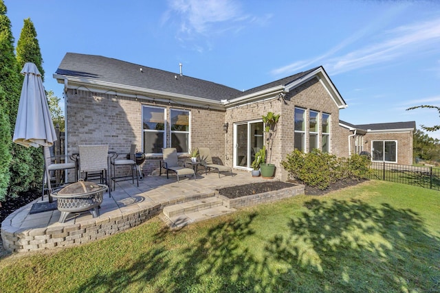 rear view of house with a patio area, an outdoor fire pit, and a lawn