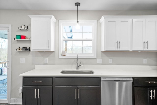 kitchen featuring pendant lighting, sink, white cabinetry, and stainless steel dishwasher