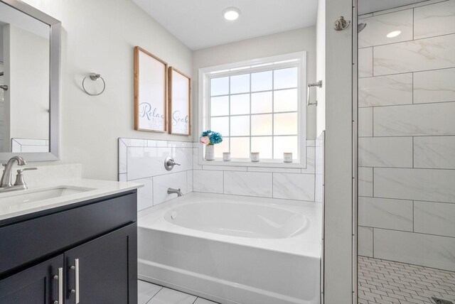 bathroom featuring vanity, shower with separate bathtub, and tile patterned flooring