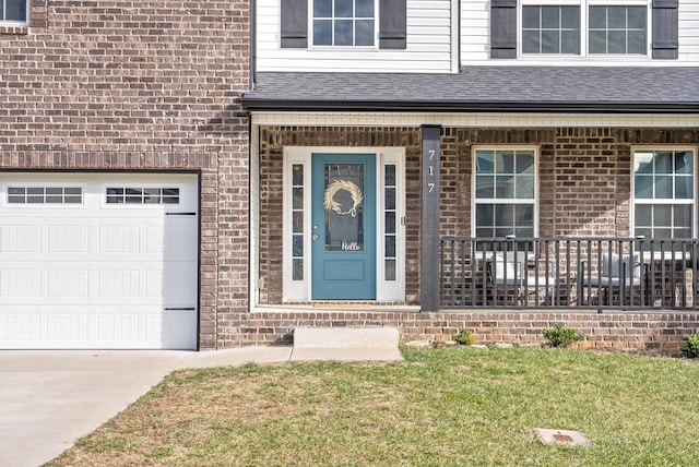 view of exterior entry with a garage and a lawn